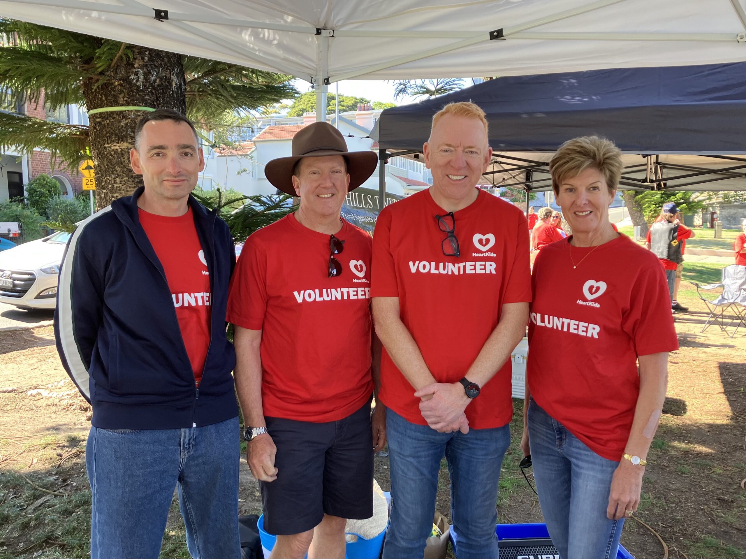 Seven Consulting Image of four people in red HeartKids volunteer t-shirts.